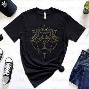 Puede incluir: Camiseta negra con un dise&ntilde;o de flor de loto dorada. El gr&aacute;fico floral presenta detalles intrincados y detalles de cadena colgante. La camiseta se combina con gafas de sol, una gorra negra, zapatillas deportivas y vaqueros.
