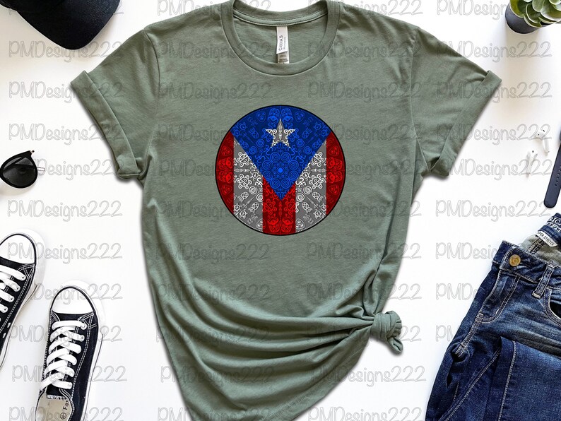 May include: A green t-shirt with a circular design featuring the Puerto Rican flag. The flag is surrounded by a white pattern.