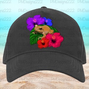 May include: A black baseball cap featuring a brown frog perched on a bed of green leaves and colourful hibiscus flowers. The flowers are purple, pink, and red.