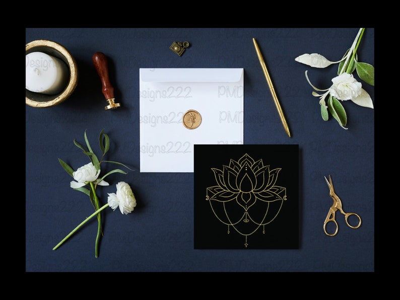 Puede incluir: Composici&oacute;n plana con un dise&ntilde;o de flor de loto dorada sobre un cuadrado negro, un sobre blanco con un sello dorado, un bol&iacute;grafo dorado y unas tijeras doradas. Flores blancas y una vela en un cuenco dorado tambi&eacute;n presentes, todo sobre una superficie azul oscuro.