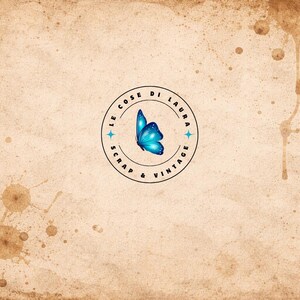 May include: A vintage-style background with coffee stains and a central circular logo. The logo features a blue butterfly and the text "LE COSE DI LAURA SCRAP & VINTAGE" in a circular arrangement, with star accents.