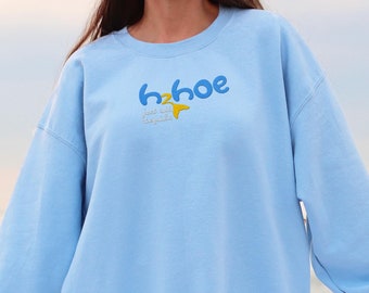 May include: A light blue sweatshirt with the text "h2oe just add sunshine" in blue and yellow lettering.