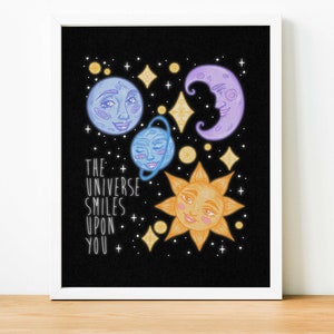May include: A black background with a purple crescent moon, a blue planet, a blue planet with a ring, and a yellow sun with a smiling face. The text "THE UNIVERSE SMILES UPON YOU" is written in white.