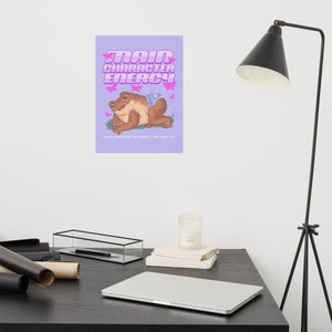 May include: A purple background with pink text that reads "Main Character Energy". A cartoon frog wearing a blue and white patterned outfit is sitting on a green leaf with pink butterflies flying around it.