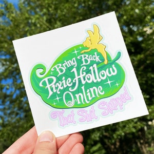 Può includere: Un adesivo a forma di foglia verde con una fata in cima. L'adesivo dice "Bring Back Pixie Hollow Online That Shit Slapped".