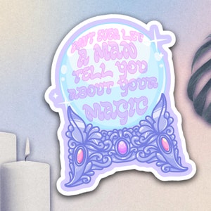 May include: A sticker featuring a crystal ball design with the text "DON'T EVER LET A MAN TELL YOU ABOUT YOUR MAGIC" in a whimsical font. The sticker has a light blue and purple color scheme with decorative accents.