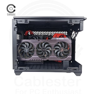 May include: A black computer case with a graphics card featuring three fans. The graphics card has a grey and black design with the ASUS logo. Red cables are visible inside the case. The text "TUF GAMING" is on the graphics card.