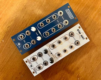 Pode incluir: Dois módulos de sintetizador, um azul e outro branco, com botões e conectores. O módulo azul é etiquetado como "Stardust" e o módulo branco como "Star Dust".