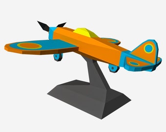 May include: A small, orange and blue model airplane on a black stand. The airplane has a yellow canopy and a circular design on the wings and tail.