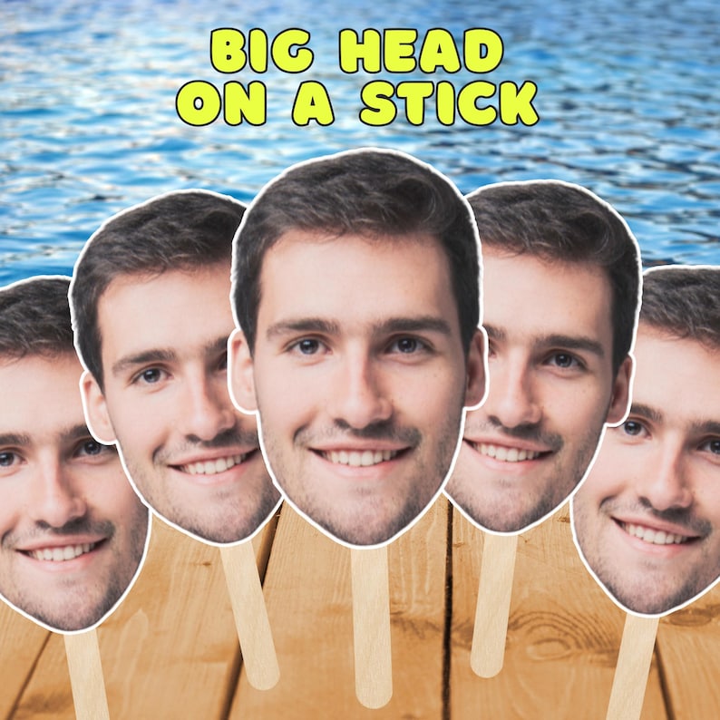 Puede incluir: Cinco recortes de caras en palos, cada uno con la cara sonriente de un hombre. El texto "BIG HEAD ON A STICK" est&aacute; en amarillo sobre las caras. El fondo es azul y blanco, con madera debajo.