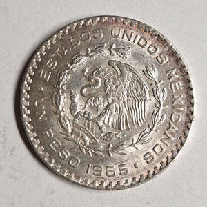 Mexican silver Un Peso coin in excellent condition. The coin you see is the coin you get!
