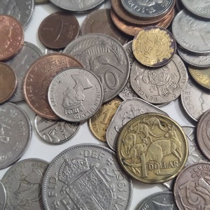 May include: A collection of various coins, including silver, copper, and gold pieces. The coins display different designs, including portraits, animals, and inscriptions. Some coins are marked with the text "DOLLAR" and "CANADA".