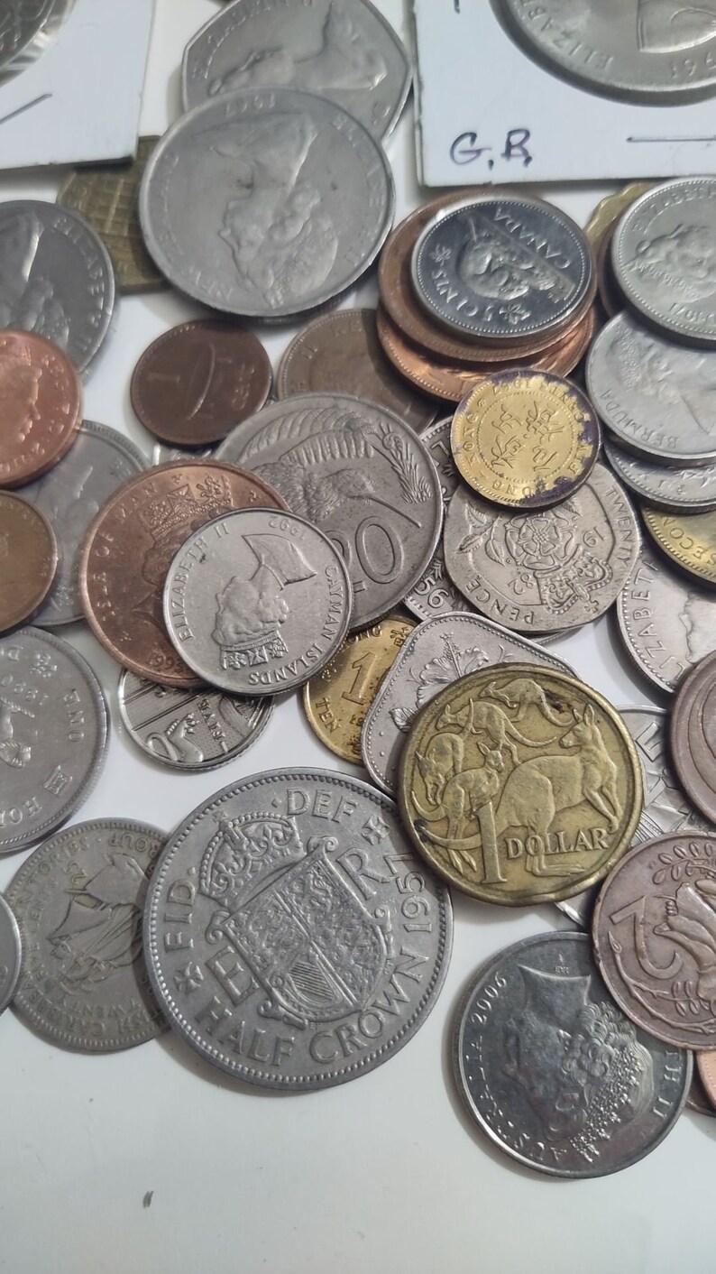May include: A collection of various coins, including silver, copper, and gold pieces. The coins display different designs, including portraits, animals, and inscriptions. Some coins are marked with the text "DOLLAR" and "CANADA".