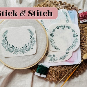 May include: A set of three embroidery hoop kits with floral designs. The kits include white fabric, green embroidery floss, and a wooden hoop. The text "Stick & Stitch" is visible in the image.