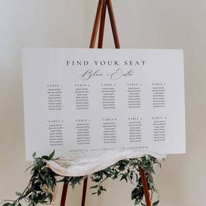Könnte beinhalten: Ein weißer Hochzeitssitzplan mit dem Text "Find Your Seat Blair + Eastin" oben. Der Plan listet die Gäste nach Tischnummer auf, mit Namen wie Sarah Smith, Samuel Smith, Julia Hope, Keith Parker, Keira Sutton, James Logan und Jenny Monty. Der Plan ist datiert auf den 24. August 2027 und gibt den Ort als Los Angeles, Kalifornien an.