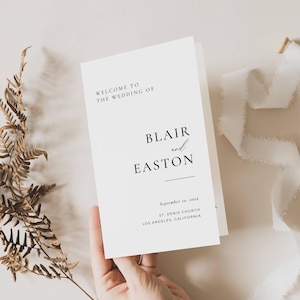 Pode incluir: Um cartão de programa de casamento branco com texto em preto que diz: WELCOME TO THE WEDDING OF BLAIR and EASTON, SEPTEMBER 10, 20XX, ST. DENIS CHURCH, LOS ANGELES, CALIFORNIA. O cartão tem um layout limpo com fontes serifadas e manuscritas.