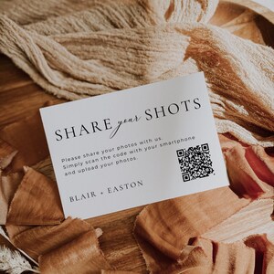 Pu&ograve; includere: Una carta rettangolare bianca con testo nero che recita SHARE your SHOTS, Please share your photos with us. Simply scan the code with your smartphone and upload your photos. BLAIR + EASTON, e un codice QR in bianco e nero a destra.