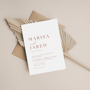 May include: A white wedding invitation with a brown envelope and a dried palm leaf. The invitation reads "Marisa and Jared" in a red font. The date of the wedding is Saturday, April 22, 2024.