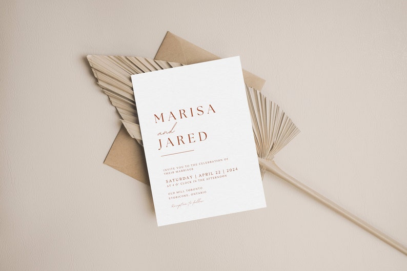 May include: A white wedding invitation with a brown envelope and a dried palm leaf. The invitation reads "Marisa and Jared" in a red font. The date of the wedding is Saturday, April 22, 2024.