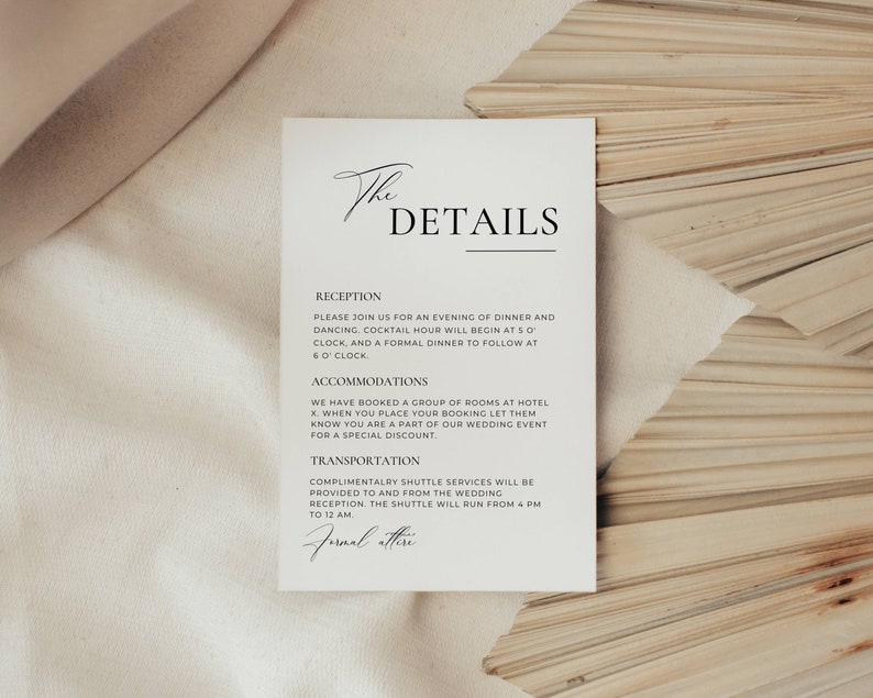 May include: A white invitation card with the text "The DETAILS" in elegant black script. The card includes details about a wedding reception, accommodations, and transportation. The card is set against a neutral background.