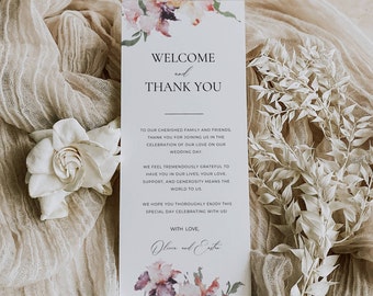 Op de afbeelding: Een trouw welkom- en bedankkaart met bloemaccenten. De kaart heeft bovenaan de tekst "WELCOME and THANK YOU", met daaronder extra tekst. De kaart is versierd met bloemen in aquarel-stijl in roze en paarse tinten.