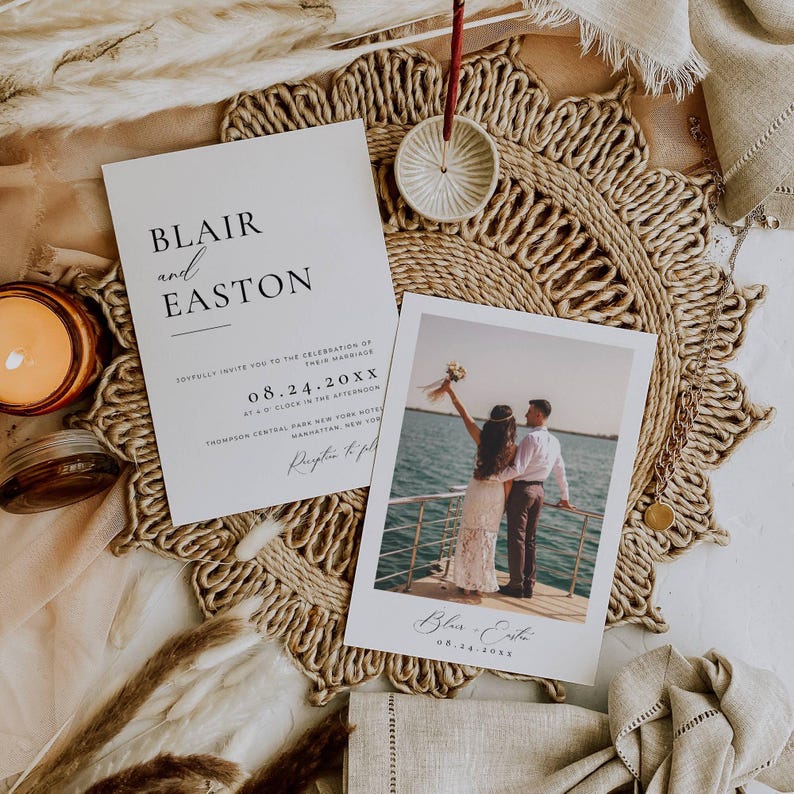 May include: Wedding invitation and photo card featuring the names "Blair and Easton" and the date "08.24.20XX". The photo card shows a couple on a boat. The cards are on a woven placemat with a candle and decorative elements.