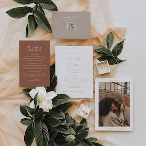 Puede incluir: Conjunto de invitaciones de boda con una tarjeta de invitación blanca, una tarjeta con foto y una tarjeta de detalles. El conjunto incluye tarjetas RSVP y de detalles, un joyero y vegetación. La paleta de colores es neutra con toques de marrón y beige.