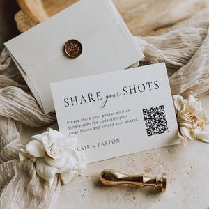 May include: A white rectangular card with black text reading SHARE your SHOTS, instructions to scan the QR code, and the names BLAIR + EASTON. The card is accompanied by a white envelope with a gold wax seal and a gold metal wax seal stamp.