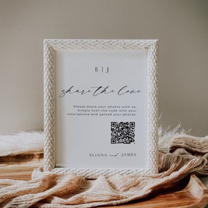 May include: White framed sign with a black and white QR code, the text "EJ share the love" and the text "Please share your photos with us. Simply scan the code with your smartphone and upload your photos. ELIANA and JAMES".