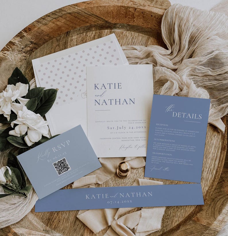 May include: A wedding invitation suite with a blue and white color scheme. The invitation features the names Katie and Nathan, the date July 14, 20XX, and a QR code for RSVP. The details card includes information about the reception, attire, and transportation.