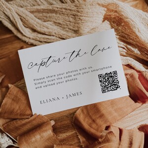 May include: White card with black text that reads "capture the love".  The card also includes instructions to share photos with a QR code and the names "Eliana + James".