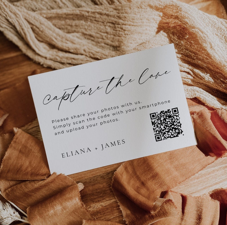 May include: White card with black text that reads "capture the love".  The card also includes instructions to share photos with a QR code and the names "Eliana + James".