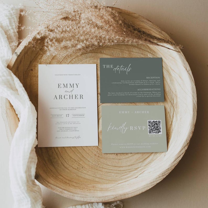 May include: A wedding invitation suite featuring three cards in a wooden bowl. The main invitation is white with the names "Emmy and Archer" and event details. Two smaller cards are sage green, one with "The Details" and the other with "Kindly RSVP".