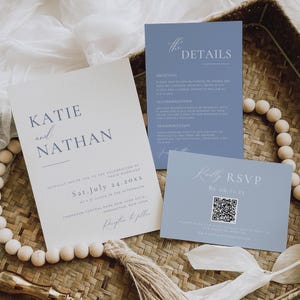 Puede incluir: Juego de papelería de boda en azul claro, con una invitación con "Katie y Nathan", detalles y tarjetas de confirmación de asistencia. Las tarjetas están dispuestas sobre una superficie tejida, ideal para una boda.