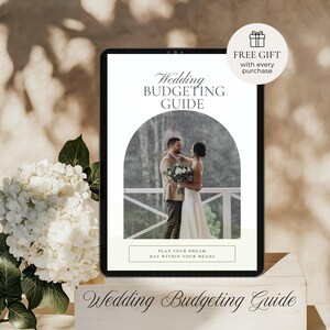 May include: A digital tablet displays a wedding budgeting guide with a photo of a couple. The text reads "Wedding Budgeting Guide" and "Plan Your Dream Day Within Your Means." A "Free Gift" offer is also shown. White flowers and a wooden block are in the foreground.