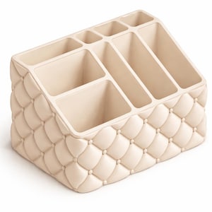 May include: A cream-coloured organiser with multiple compartments for cosmetics or office supplies. The exterior features a quilted pattern with button accents. The angled design provides easy access to the contents, making it a stylish and functional storage solution.
