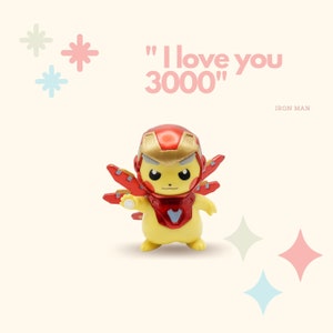 May include: A yellow Pikachu figurine wearing an Iron Man suit. The figurine is holding a repulsor beam in its right hand. The text "I love you 3000" is written in pink letters above the figurine. The text "IRON MAN" is written in black letters below the figurine.