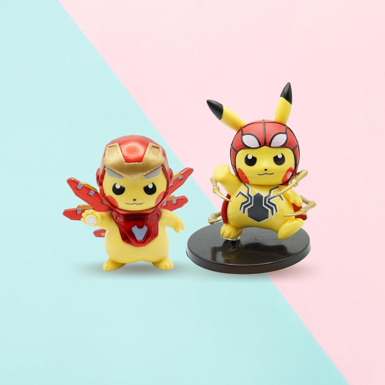 May include: Two yellow Pikachu figurines, one dressed as Iron Man and the other as Spider-Man. The Iron Man Pikachu has a red and gold suit with a red helmet. The Spider-Man Pikachu has a red and blue suit with a black spider logo.