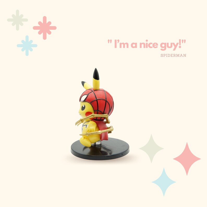 May include: A yellow Pikachu figurine wearing a red and blue Spiderman costume with a gold spider web design. The figurine is standing on a black base. The text "I'm a nice guy!" is written in pink above the figurine. The text "SPIDERMAN" is written in pink below the figurine.