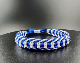 May include: A blue and white braided bracelet with a woven pattern.