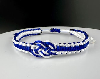 May include: A blue and white braided bracelet with a knot in the center.