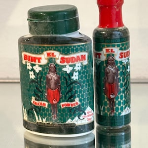 Può includere: Due piccoli flaconi di talco verde e bianco con un'etichetta rossa e bianca. L'etichetta presenta una donna con una gonna rossa su uno sfondo verde con il testo "Bint El Sudan" e "Talco in polvere".