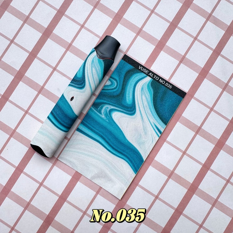 以下が含まれることがあります： 青と白の大理石模様のデザインの黒と白のVapeデバイスと、それに合わせた長方形のカード。カードには「Vuse Alto No. 035」と書かれています。「No. 035」の数字も下部に金色で印刷されています。