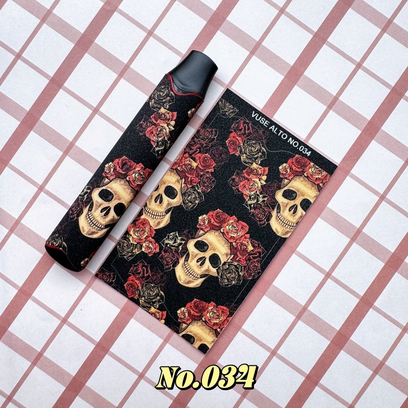 以下が含まれることがあります： 黒と赤の装飾用VAPEデバイススキンとマッチングステッカー。デザインは、黒い背景にバラの王冠をかぶった骸骨が特徴です。ステッカーには「VUSE ALTO NO.034」と「No.034」と書かれています。
