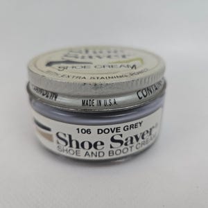 May include: A small, round jar of Shoe Saver shoe cream in Dove Grey. The jar has a metal lid and a label with the product name and colour. The text "Made in U.S.A." is visible.