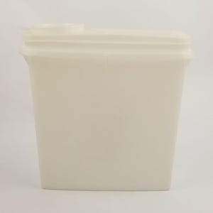 May include: A rectangular, off-white container with a small, cylindrical opening on top. The container has a slightly textured surface and a simple, minimalist design. The overall shape is a tall, narrow rectangle.