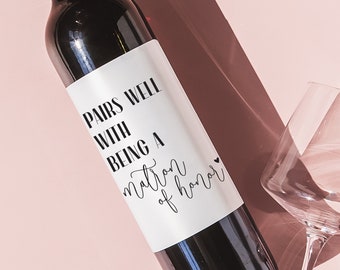 May include: A wine bottle with a white label that reads "Pairs well with being a matron of honor".