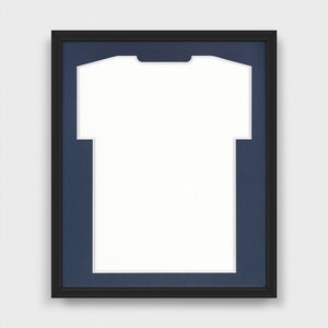 May include: A black frame with a navy blue mat and a white t-shirt cutout. The frame is designed to display a t-shirt.