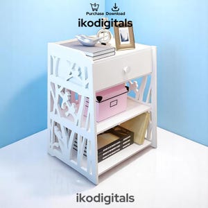 May include: White wooden nightstand with a drawer and two shelves. The nightstand has a decorative cut-out design on the front and sides. The shelves are holding books and a pink box.