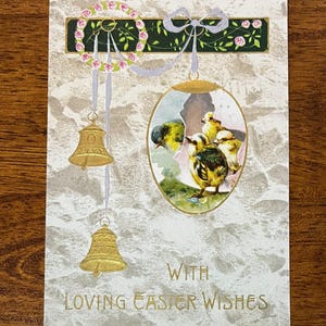 May include: Vintage Easter postcard with a decorative design. The card features an illustration of baby chicks hatching from an egg, gold bells, and the text "With Loving Easter Wishes". The background has a textured, speckled pattern.